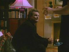 the standard lamp behind the armchair