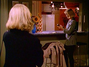 View towards the kitchen from the living room, showing the bar stools.