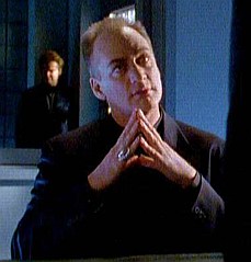 LaCroix is interrogated at the police station about the corpse at the Raven